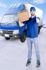 Delivery man with thumbs up and truck