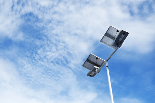 Solar cells LED light in blue sky with clouds.