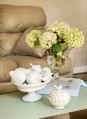 Flower vase on table top with sofa background