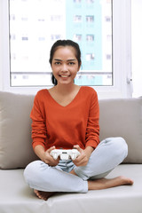 Happy asian woman with gamepad playing video games