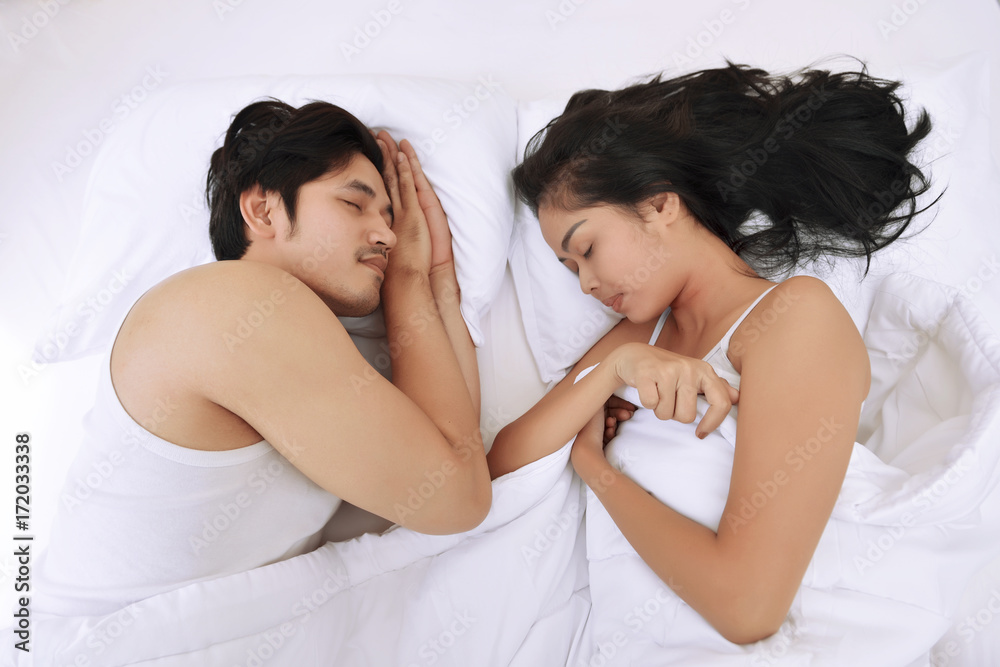 Wall mural beautiful asian couple sleeping together with comfortable