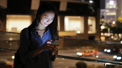 Woman using smart phone at night