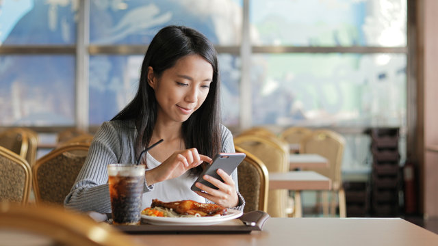 Woman eating lunch and using of mobile phone