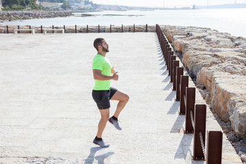 Serious Strong Man Jogging in Place Outdoors
