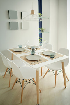 Interior of light modern dining room with served table