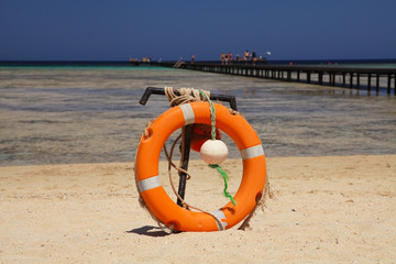 Lifebuoy on sandy beach, near coral reef. Marsa Alam, Egypt