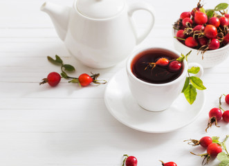 tea with berries of a dogrose on a wooden background
