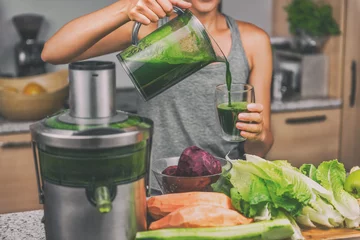 Photo sur Plexiglas Jus Jus de femme faisant du jus vert avec machine à jus dans la cuisine à domicile. Régime végétalien de désintoxication sain avec un extracteur de légumes pressé à froid pour extraire les nutriments pour une boisson smoothie.