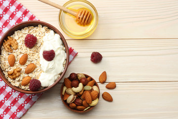 healthy breakfast. oatmeal, raspberries, honey and nuts on white wooden table. Top view with copy space