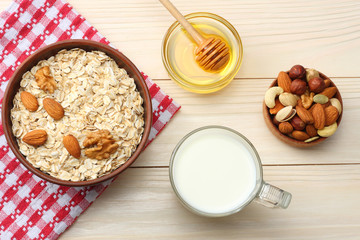 healthy breakfast. oatmeal, milk, honey and nuts on white wooden table. Top view with copy space