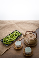 Japan pigeon pea or Edamame or Soybeans and tea pot on wooden table with area for typography