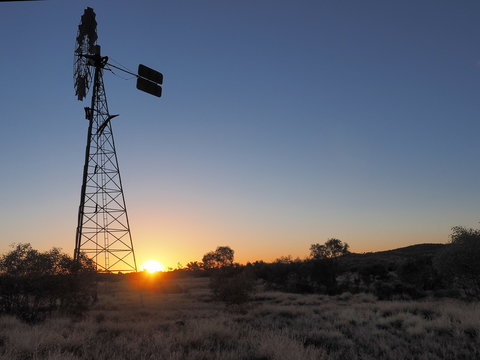 Windmill in front of sunset sky, part of a water well, Northern Territory, Australia  201t