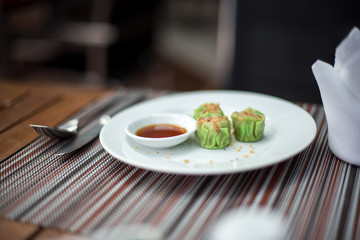Dim sum on white plate with sour sauce
