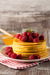 Fresh made delicious pancakes with berries, blackberries, raspberries, banana, honey and maple syrup. Healthy morning breakfast concept.