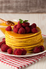 Fresh made delicious pancakes with berries, blackberries, raspberries, banana, honey and maple syrup. Healthy morning breakfast concept.