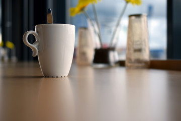 Cup of coffee on brown surface.