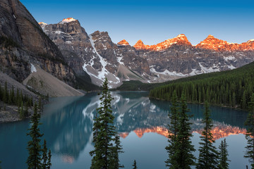 Sunrise over Moraine Lake with the reflection of the mountains, Banff National Park, Alberta, Canada.