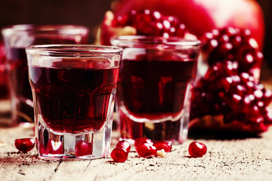 Sweet pomegranate liqueur, still life in rustic style, selective focus