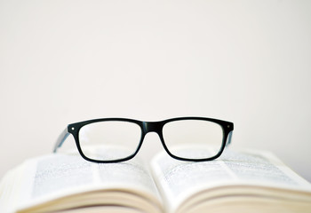 Brille auf einem aufgeschlagenen Buch.