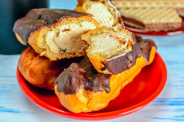 eclairs on a red plate on a wooden background
