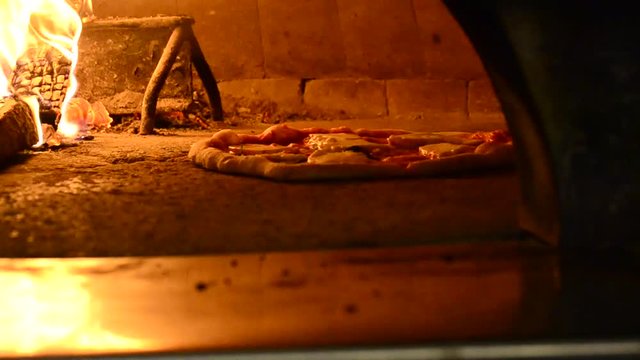 Baking pizza in traditional oven.