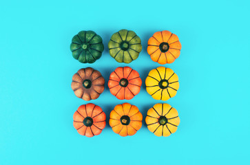 Decorative pumpkins on trendy blue background. Flat lay style.