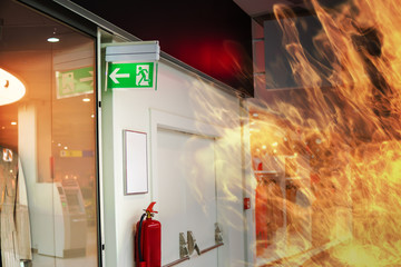 Emergency fire exit sign and fire in shopping mall. - obrazy, fototapety, plakaty