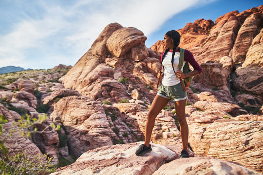 athletic african american woman standing on cliff edge at red rock canyon park