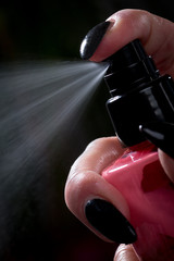 Female hairdresser applying spray on client's hair. Female hairdresser works on woman hair in salon