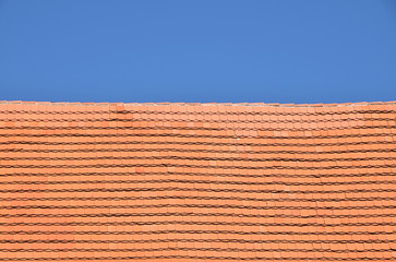 Red brown ceramic roof tiles over blue sky