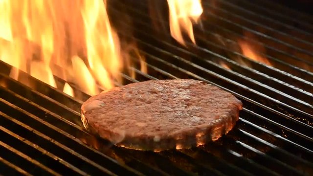 Burger meat on grill and fire.
