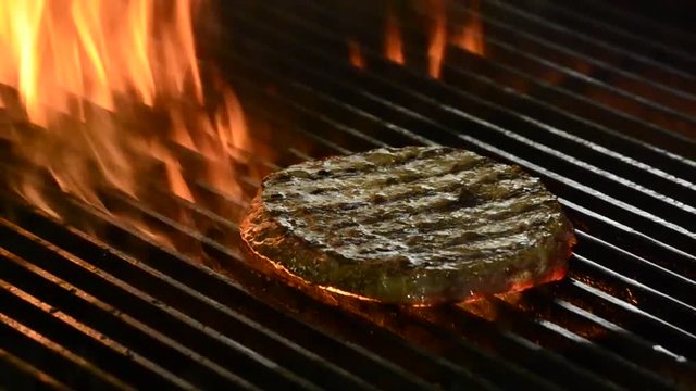 Burger meat on grill and fire.