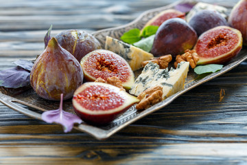Figs,blue cheese and walnuts on a bronze tray.