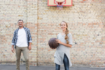 father and daughter playing basketball