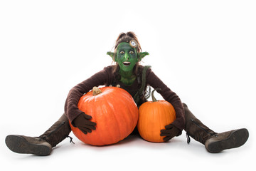 weiblicher grüner Goblin mit Kürbissen, Halloween - obrazy, fototapety, plakaty