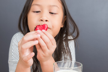 Cute little girl eating sweet macarons