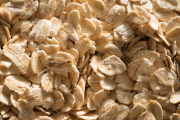 Dry rolled oat flakes oatmeal on old wooden