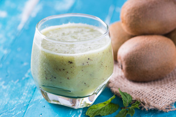 green kiwi juice, smoothie on wooden background. healthy drink in a glass. diet. summer drink and refreshment.