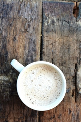 Top view of a coffee cup or cappuccino on an aged wooden table 