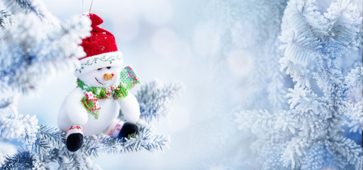 Christmas Snowman Hanging on a Snow Tree Branch
