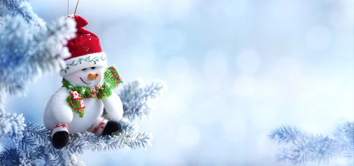 Christmas Snowman Hanging on a Snow Tree Branch