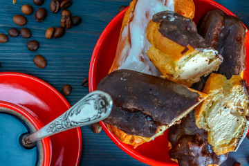 eclairs on a red plate on a wooden background