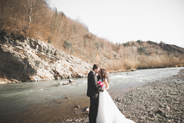 Wedding couple, groom and bride hugging, outdoor near river