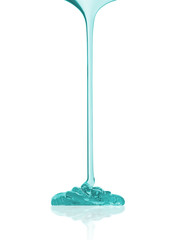 Viscous transparent liquid flows close-up over a white background