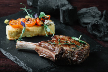 Grilled ribeye steak with polenta on dark background