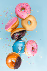 flying doughnuts scene - mix of multicolored sweet donuts with sprinkel on blue background