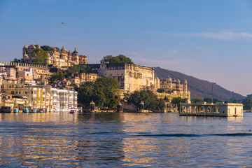 Fototapeta premium Udaipur cityscape with colorful sky at sunset. The majestic city palace on Lake Pichola, travel destination in Rajasthan, India