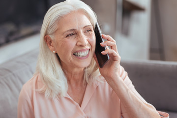 Joyful senior woman talking on smart phone