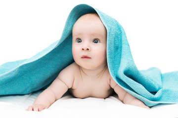 baby girl or boy with big blue eyes after shower with towel on head lying on soft blanket, isolated on white background