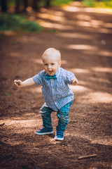 father walks with the little son in the park, the kid takes the first steps